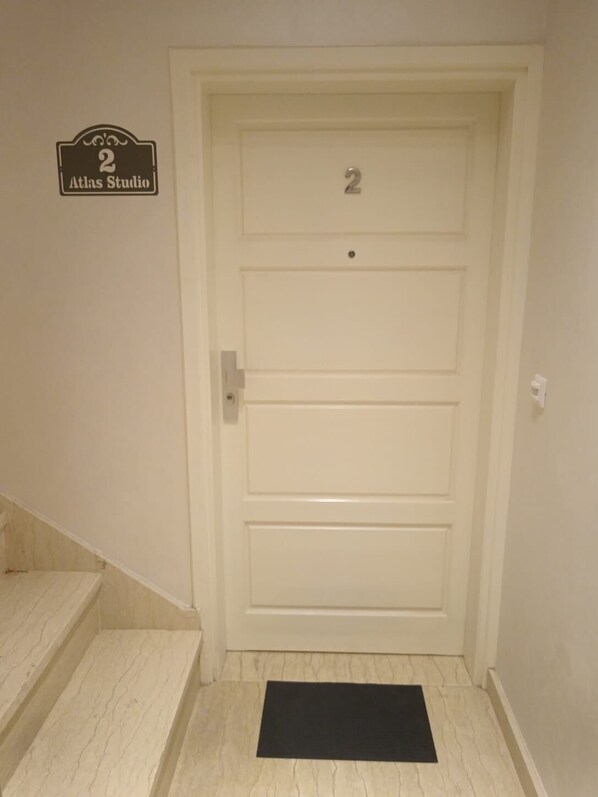 A white door with the number 2 and a sign above it that reads "Atlas Studio".