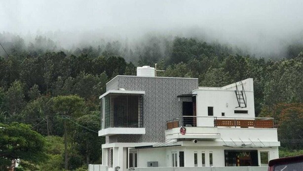 A modern two-story building with a flat roof and a visible water tank on the roof. - Hk Grand Inn By K Hotels (Yercaud)