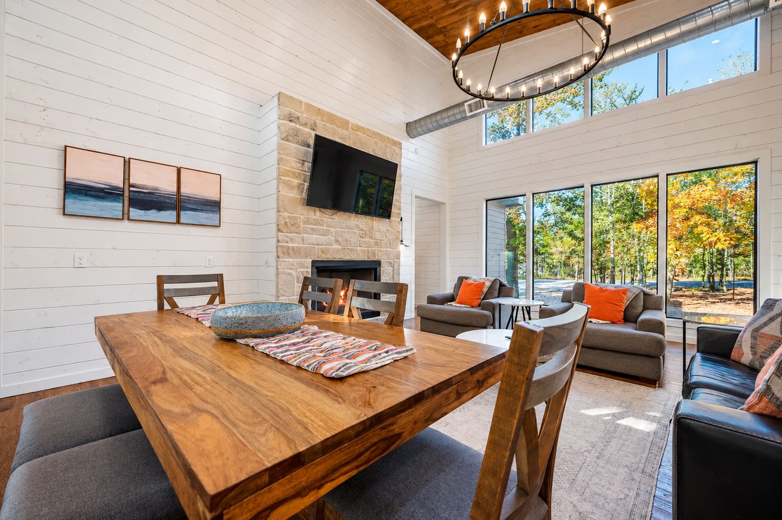 Un amplio espacio habitable con chimenea, una mesa de comedor y un conjunto de asientos.