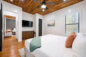 A bedroom with a bed, a television, a dresser, and a window with blinds. - Family Escape | Hot Tub + Playset | Sleeps 10 (Broken Bow)