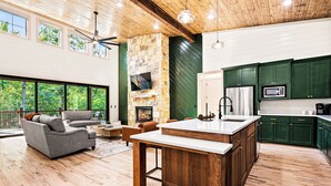 A spacious living area with a fireplace, a large sofa, and a dining table. - Play & Stay | 4BR Playset, Pool/Ping Pong, Arcade (Broken Bow)