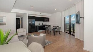 A modern living room with a dining area, a kitchen, and a balcony with a view. - Lux 2 BD Condo at The Biscayne Boulevard #3009 (Miami)