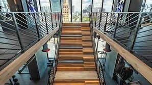 A staircase with wooden steps and metal railings, leading to a higher floor with a city view. - Lux 2 BD Condo at The Biscayne Boulevard #3009 (Miami)
