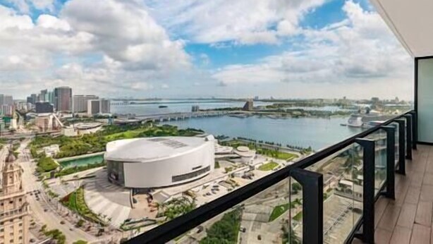 A modern building with a circular central structure, surrounded by greenery and a waterfront view. - Luxury 3 BD Condo at The Biscayne Bay #2701 (Miami)