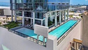 A modern hotel with a rooftop pool, large glass windows, and a view of the city skyline. - Luxury 3 BD Condo at The Biscayne Bay #2701 (Miami)