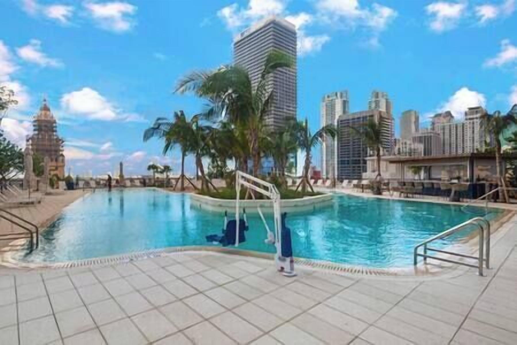 A swimming pool with tiled flooring and a metal railing.