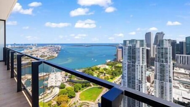 Un immeuble de grande hauteur offrant une vue sur le paysage urbain et un plan d’eau.