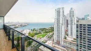 Un balcon offrant une vue sur des immeubles de grande hauteur et sur une étendue d’eau.