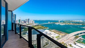 Un balcón con vistas a un paisaje urbano y un puerto deportivo.