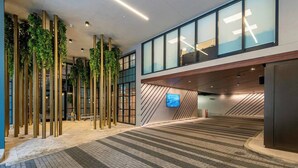 A modern indoor space with a brick floor, vertical greenery, and a large digital screen on the wall.