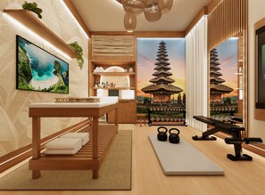 A modern spa room with a wooden massage table, a small seating area, a yoga mat, kettlebells, and a wall-mounted TV. - Voyage Grand 14 BD/ 15.5 BA/ Paradiso Grande (6091 HS) (Orlando)