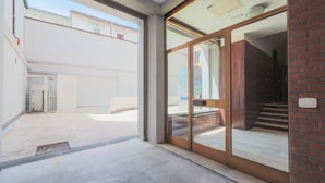A modern building entrance with a glass door, a metal gate, and a concrete floor. - The prestigious corner of Forli (Forlì)