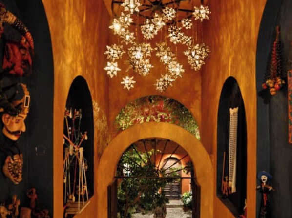 An interior with arched doorways, a chandelier, and wall decorations.