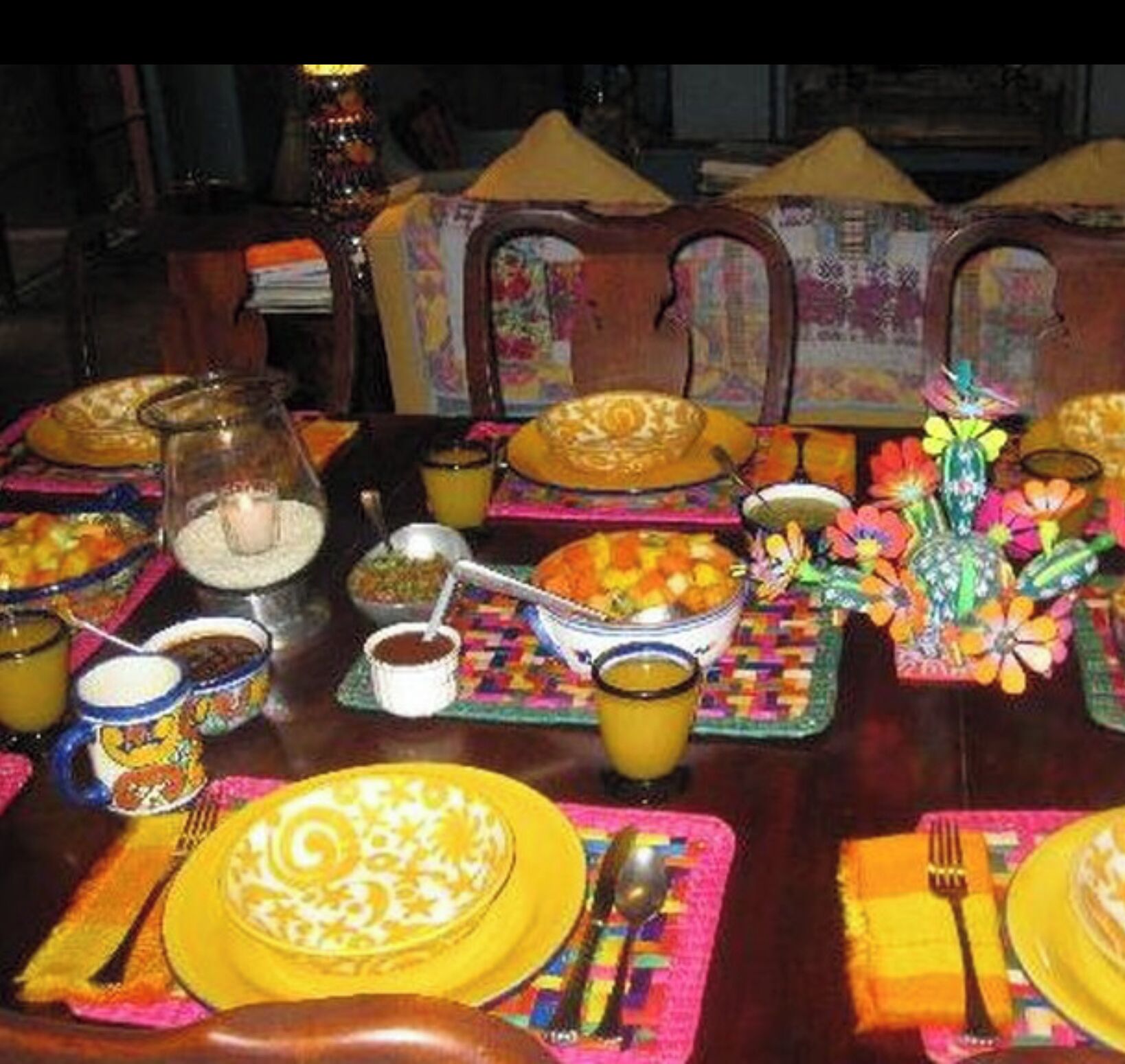 A dining table set with colorful tableware and decorative items.