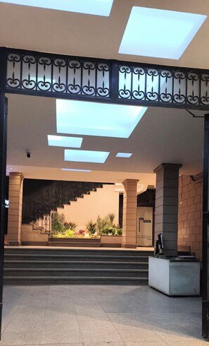 Une entrée moderne avec un escalier, un comptoir d’accueil et une enseigne indiquant « Design de qualité ».