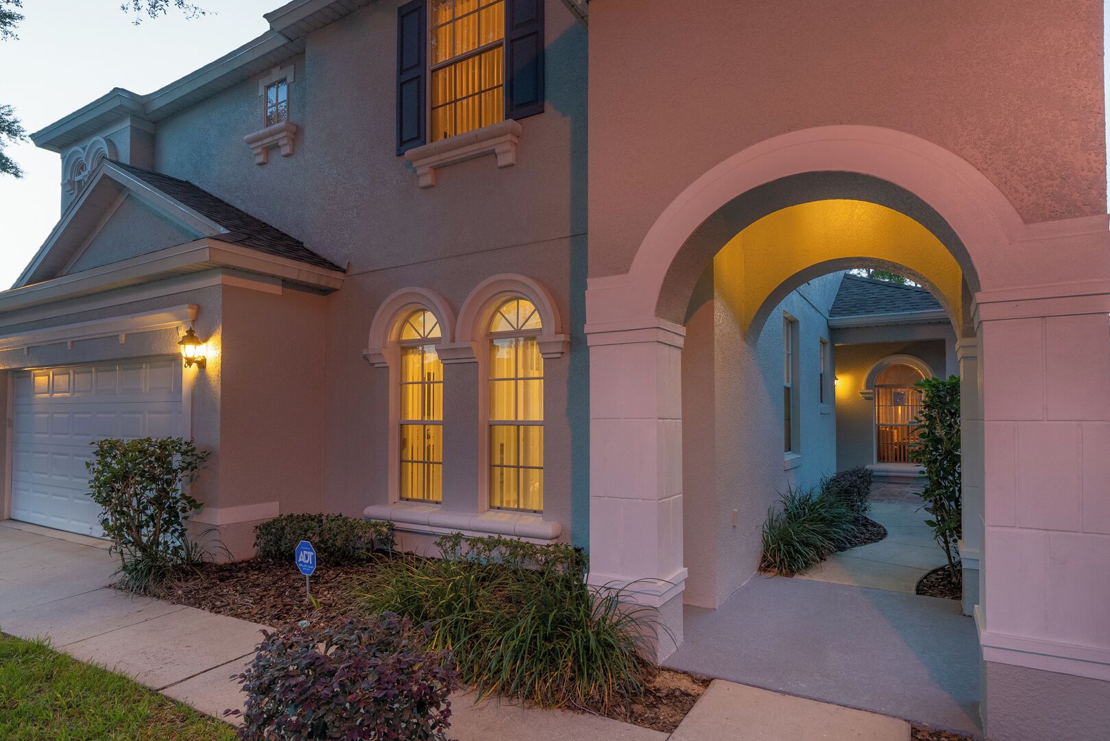 A two-story house with a garage, a covered entryway, and a well-maintained front yard.