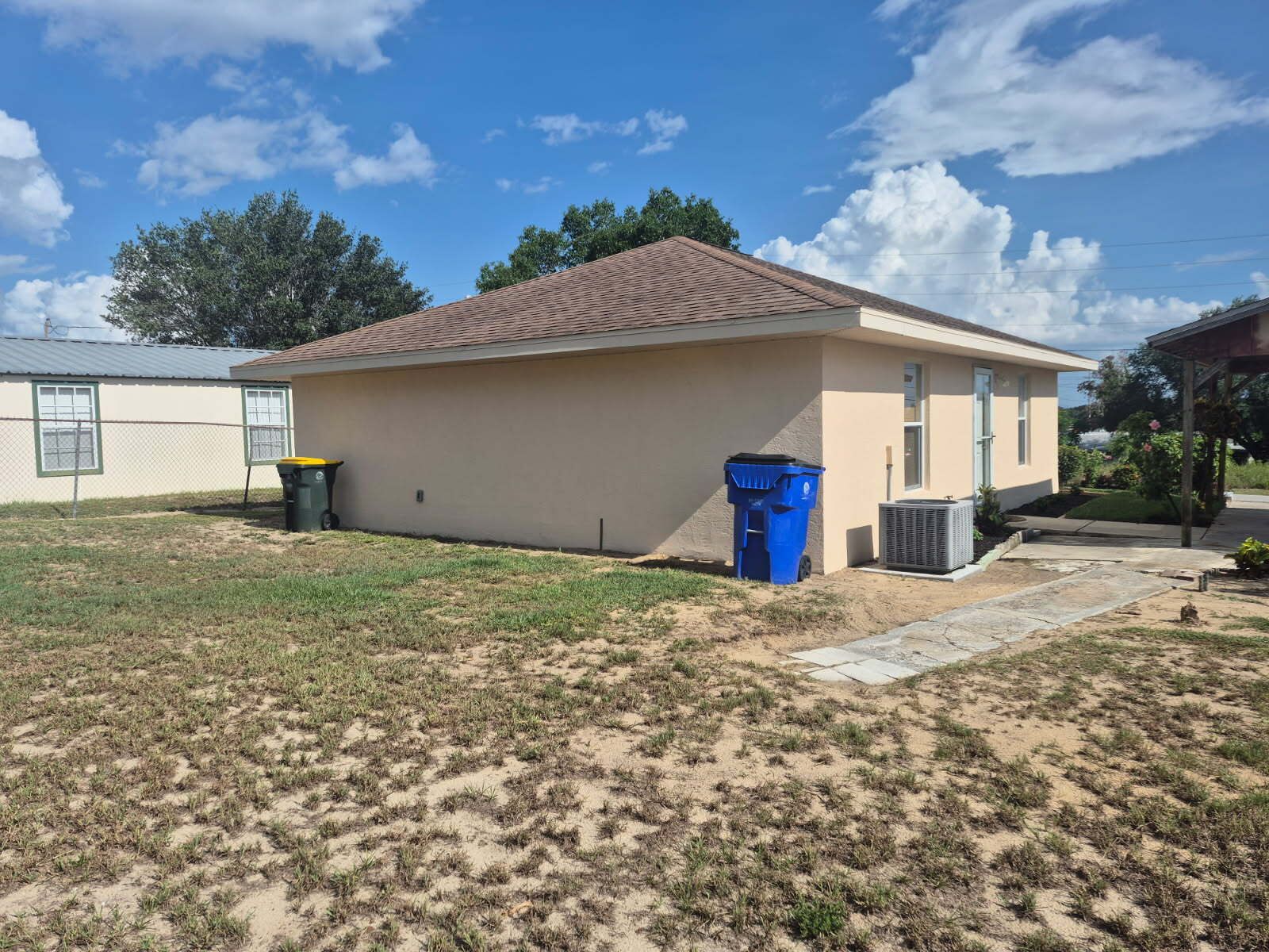 A single-story building with a flat roof and a small front yard.