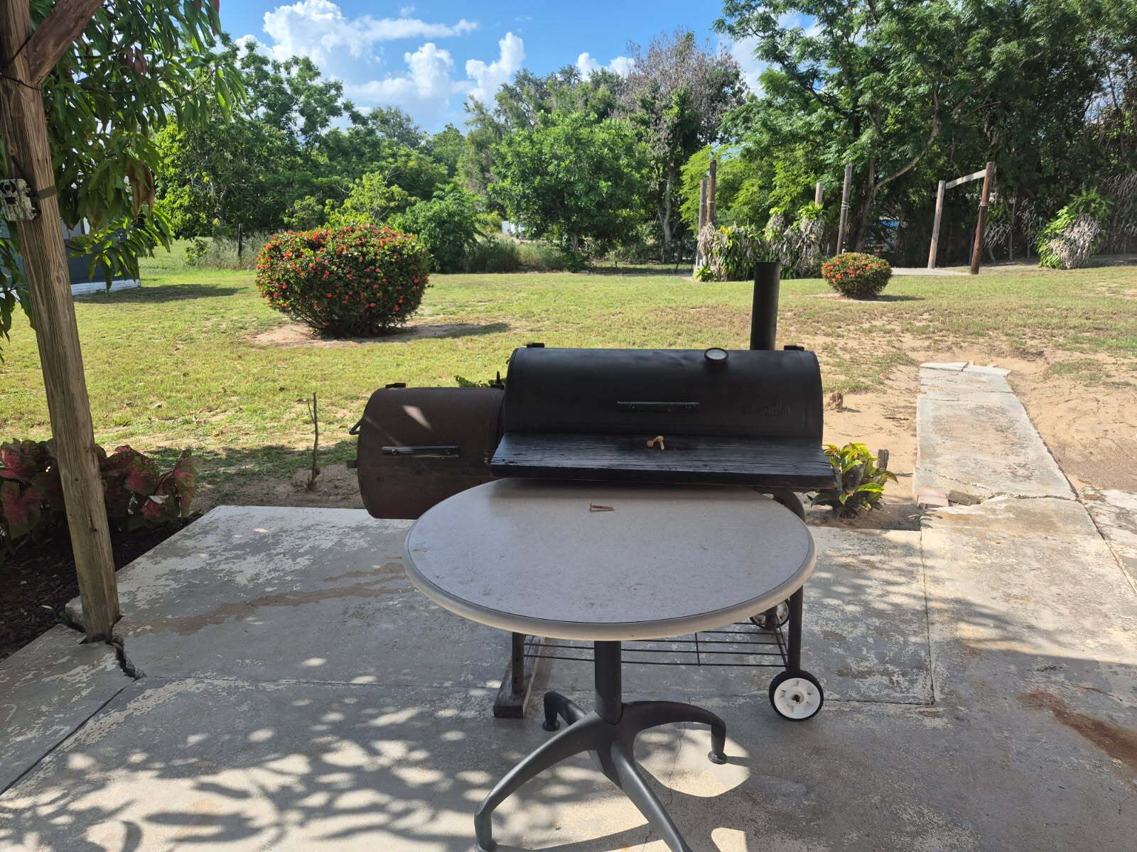 Une terrasse extérieure avec un barbecue et une table.