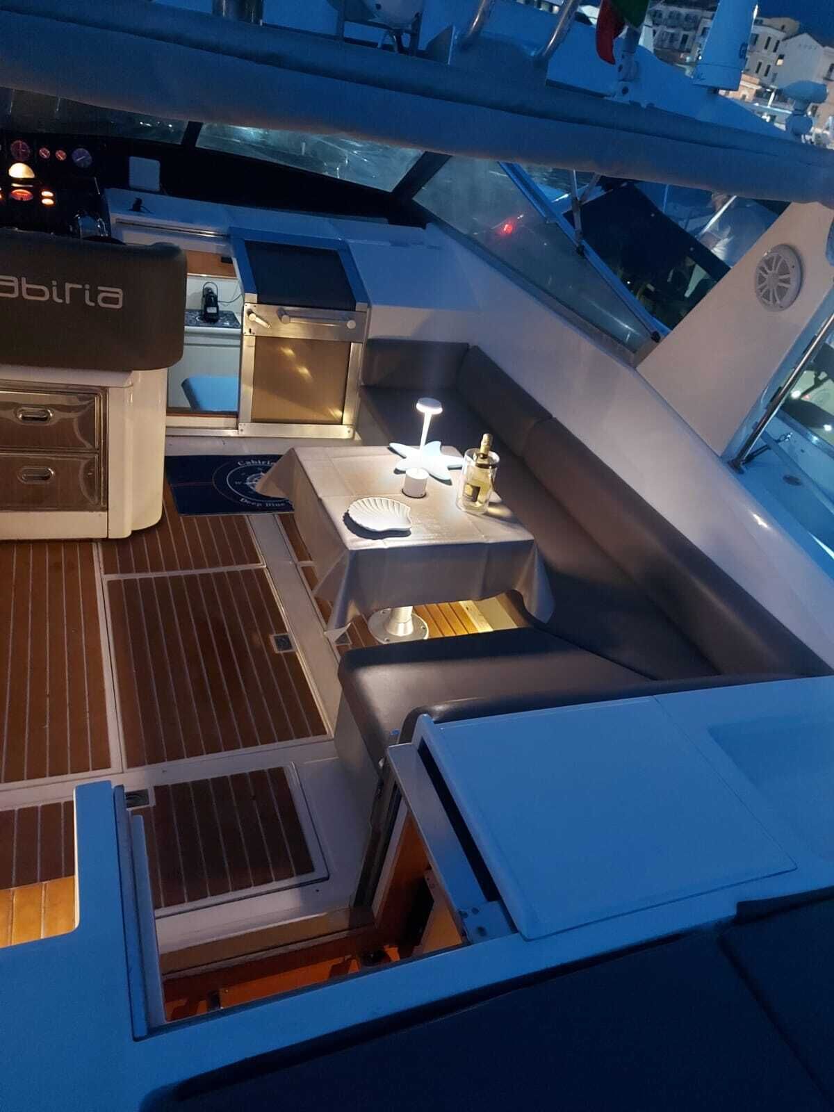 A yacht's deck with a seating area, a small bar, and a control station.