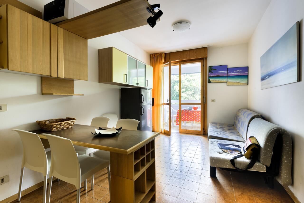 Un espace de vie compact comprenant un coin repas, une kitchenette et un canapé.