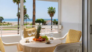A balcony with a table set for two, featuring a fruit platter, glasses, and a view of the beach. - Comeback Looking for the Summer (Motril)