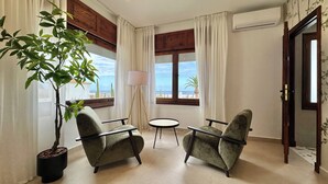 A room with two armchairs, a small table, a floor lamp, and a potted plant. - GOLF SEA&POOL CACTUS VILLA (Buenavista del Norte)