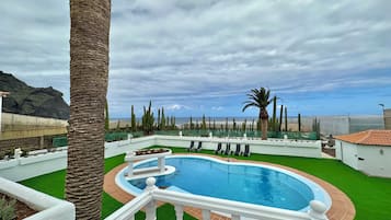 Alberca al aire libre y camastros