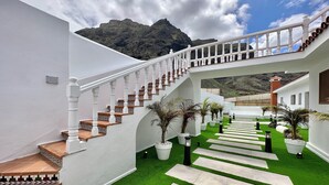 A modern staircase with white balustrades leading to a covered area with artificial grass and potted plants. - GOLF SEA&POOL CACTUS VILLA (Buenavista del Norte)