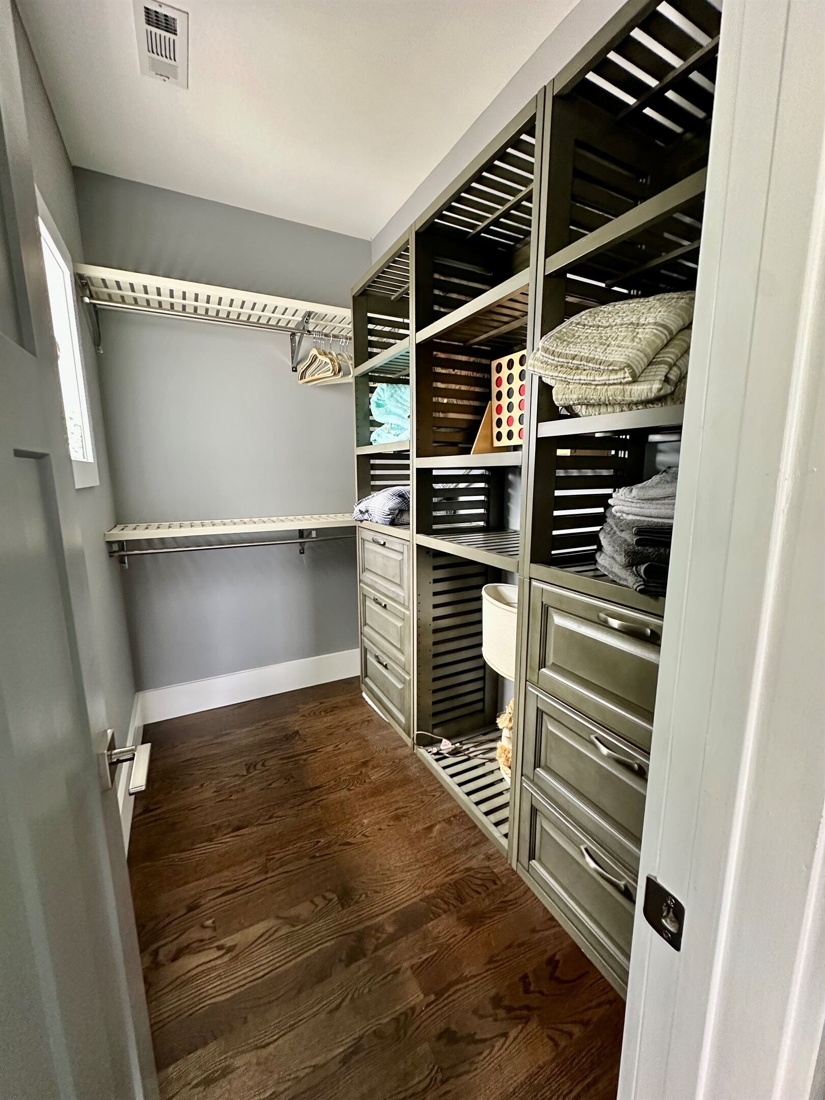 A walk-in closet with open shelving, drawers, and hanging space.