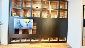 Un'elegante parete attrezzata moderna con ripiani multipli, una televisione e oggetti decorativi.