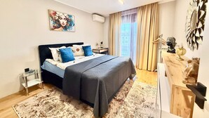 Camera da letto moderna con un letto, un comodino, uno specchio e una finestra con tende.