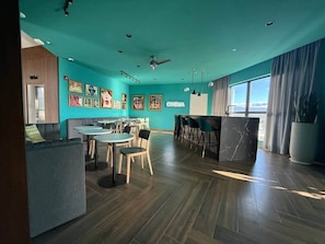 A modern interior with teal walls, a bar area, and a seating arrangement.