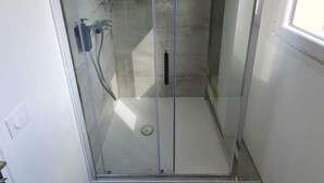 A glass-enclosed shower with a tiled floor and a visible showerhead. - Separate F2 near RER&TGV and amenities (Massy)