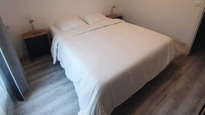 A bedroom with a single bed, a nightstand, and a bedside table. - Separate F2 near RER&TGV and amenities (Massy)