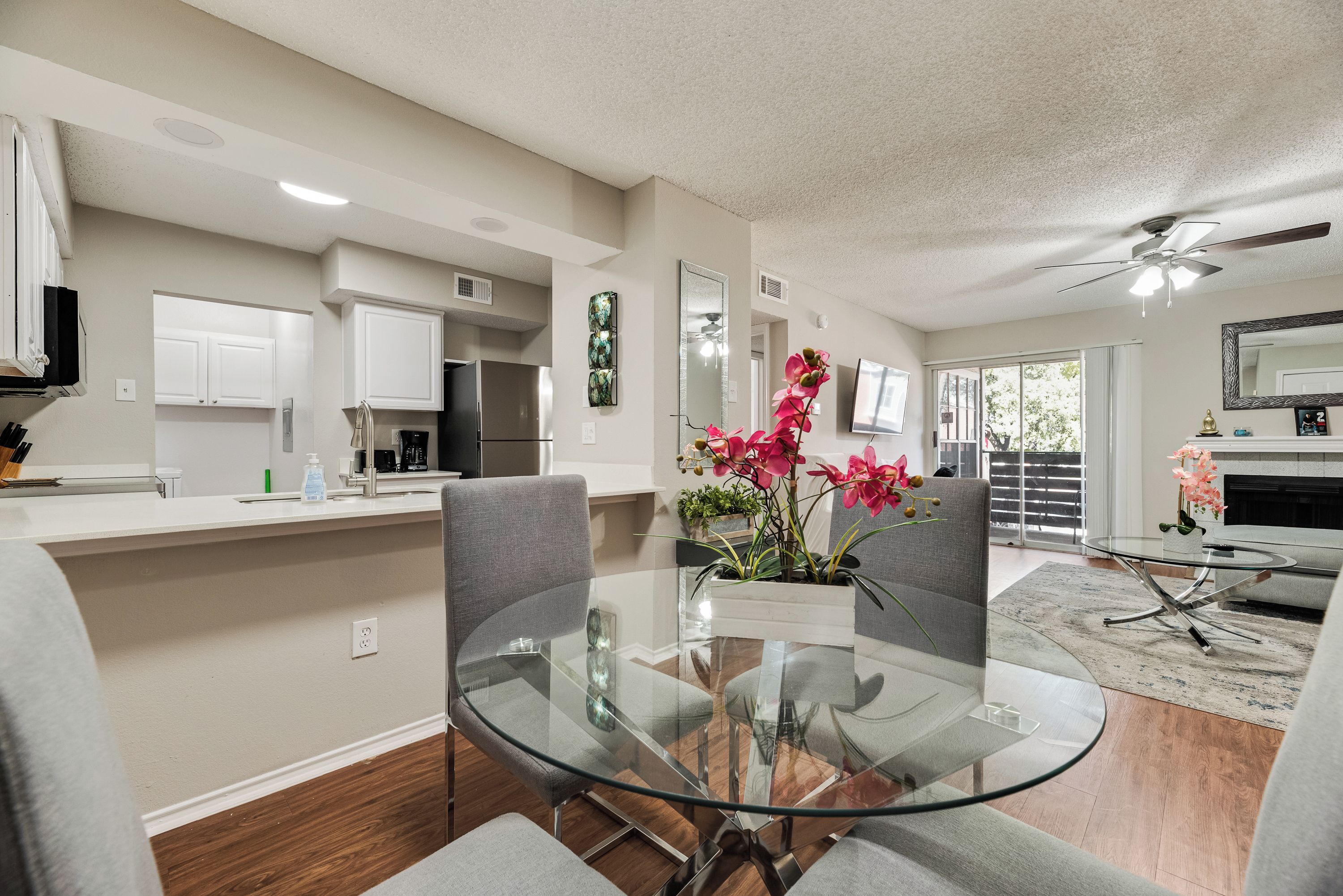 A modern kitchen with white cabinets, a stainless steel refrigerator, and a coffee maker.