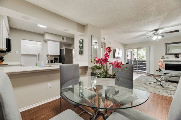 A modern kitchen with white cabinets, a stainless steel refrigerator, and a coffee maker.