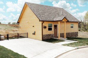 A log cabin with a stone foundation, a front door, and a small porch. - Entire Cabin in Linn, MO with all the extras (Linn)