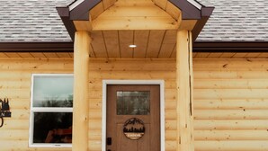 A log cabin with a stone foundation, a wooden front door, and a small window. - Entire Cabin in Linn, MO with all the extras (Linn)