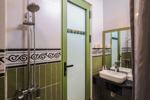 A bathroom with a shower, sink, and mirror.