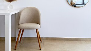 Une pièce moderne avec une table blanche, une chaise beige et trois miroirs ronds accrochés au mur.