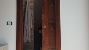 Eine Holztür führt zu einem Badezimmer, an der Wand hängt ein Handtuch.
