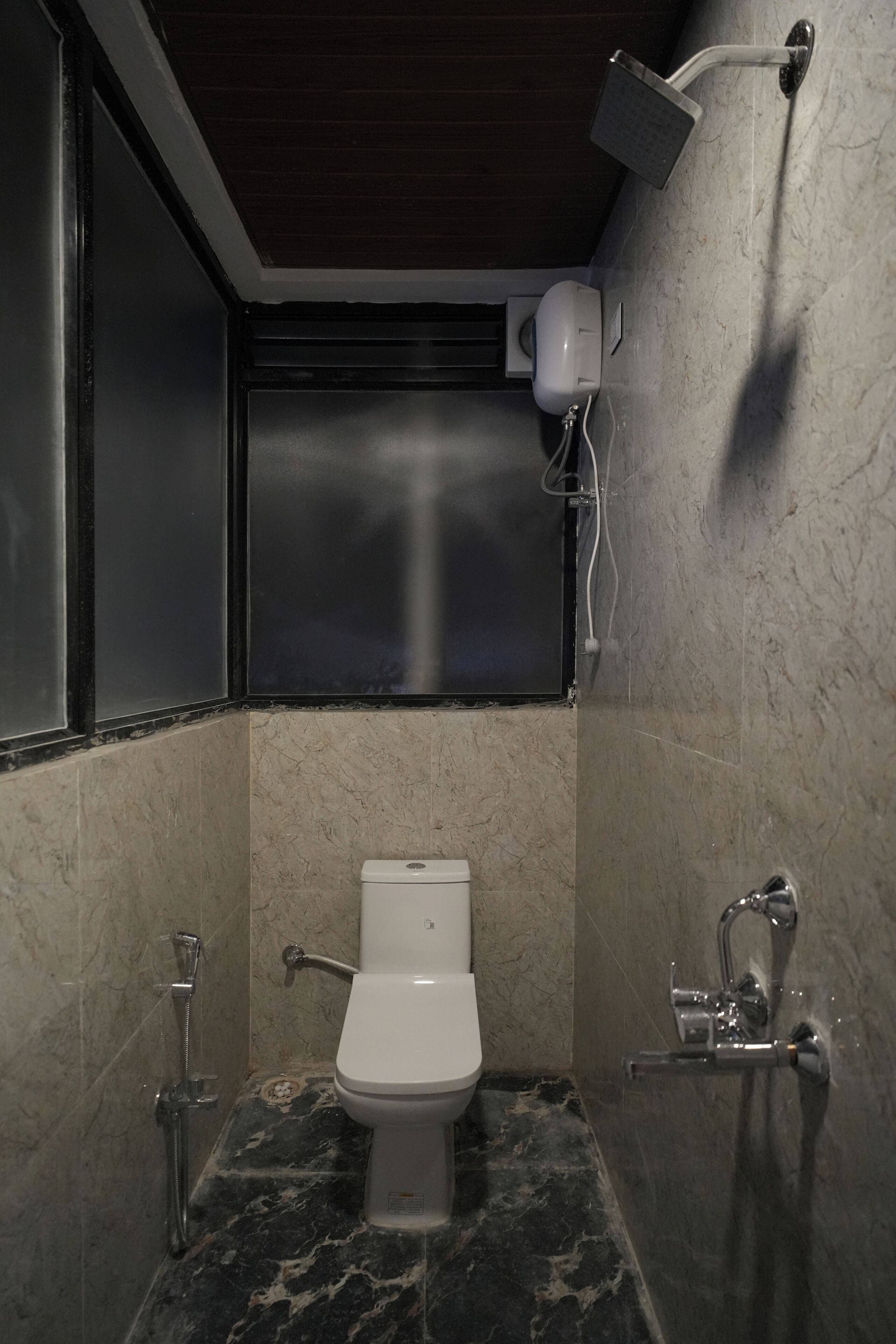 A modern bathroom with a toilet, a shower, and a hand dryer.