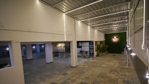 A hotel corridor with a tiled floor, potted plants, and a sign indicating free WiFi.