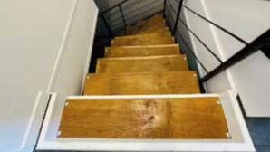 A staircase with wooden steps and black railings, leading to a landing. - New, modern, fully-equipped home (La Ferté-Saint-Cyr)