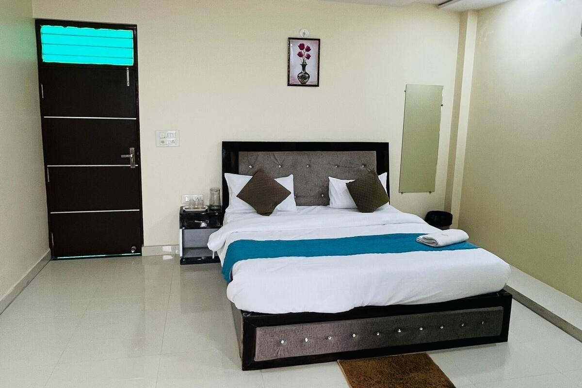 Una camera da letto ordinata con un letto, un comodino, un quadro appeso al muro e una ventola a soffitto.
