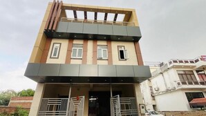 A two-story building with a flat roof, a balcony on the upper floor, and a gated entrance. - Hotel The Majestic Taj (Agra)