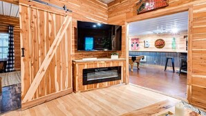 Ein Holzinnenraum mit Fernseher, Kamin und Holzwänden.