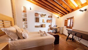 A cozy bedroom with a wooden bed, a small desk, and a shelf with decorative items.