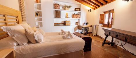 A cozy bedroom with a wooden bed, a small desk, and a shelf with decorative items.