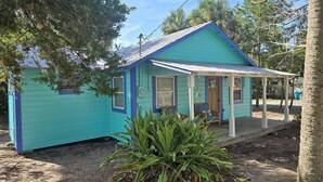 A small, single-story house with a blue exterior and a porch.